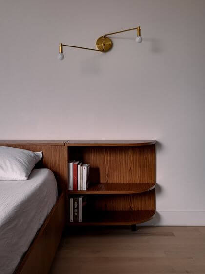 15- A singular headboard with a piece of furniture with soft lines 